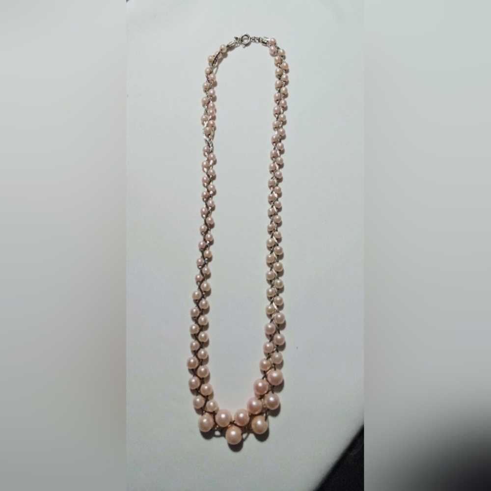 Faux light pink pearl necklace with sterling silver throughout necklace.